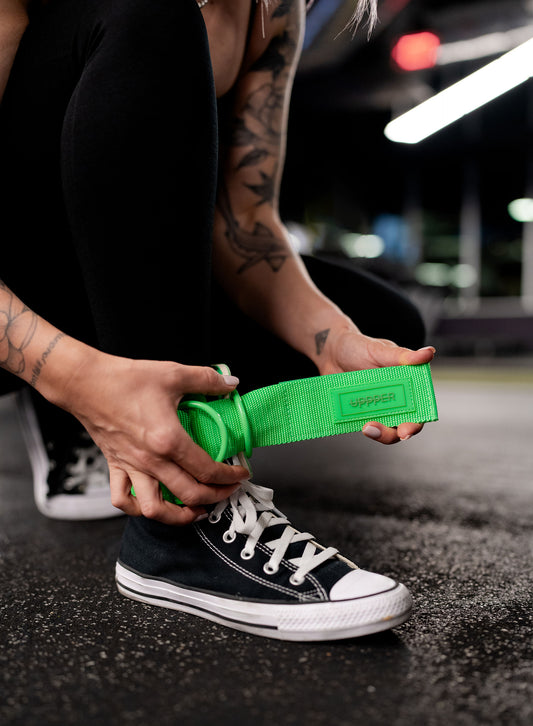 woman putting on uppper ankle straps neon green